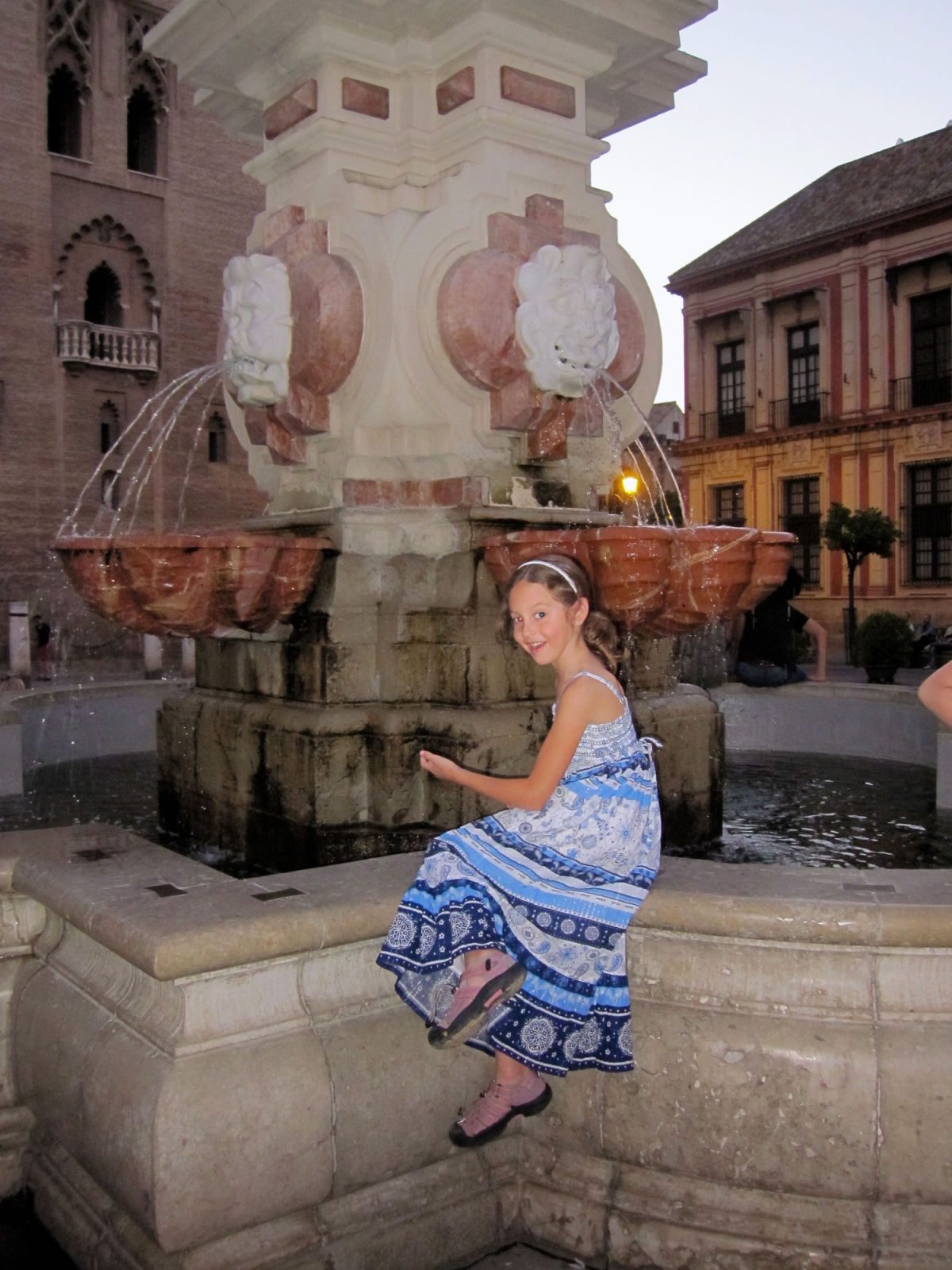 Girl playing in a fountain in Seville