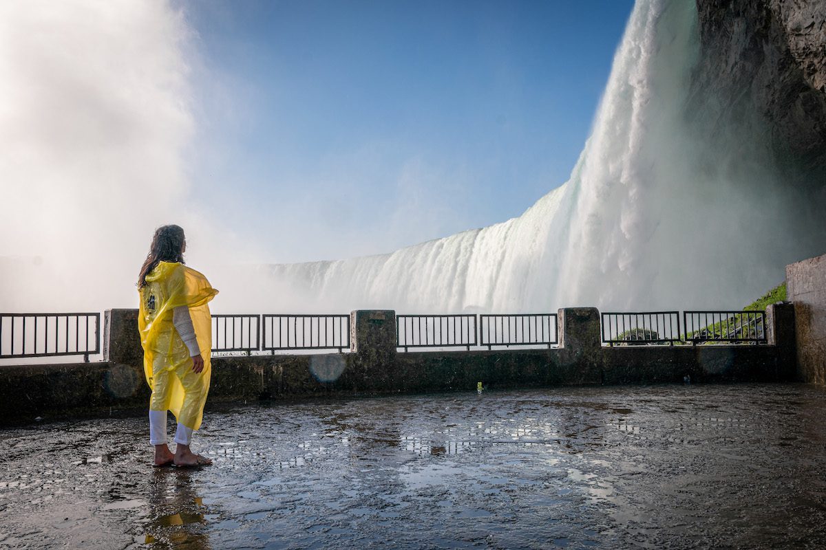 Woman on platform in yellow poncho on Journey behind the Falls