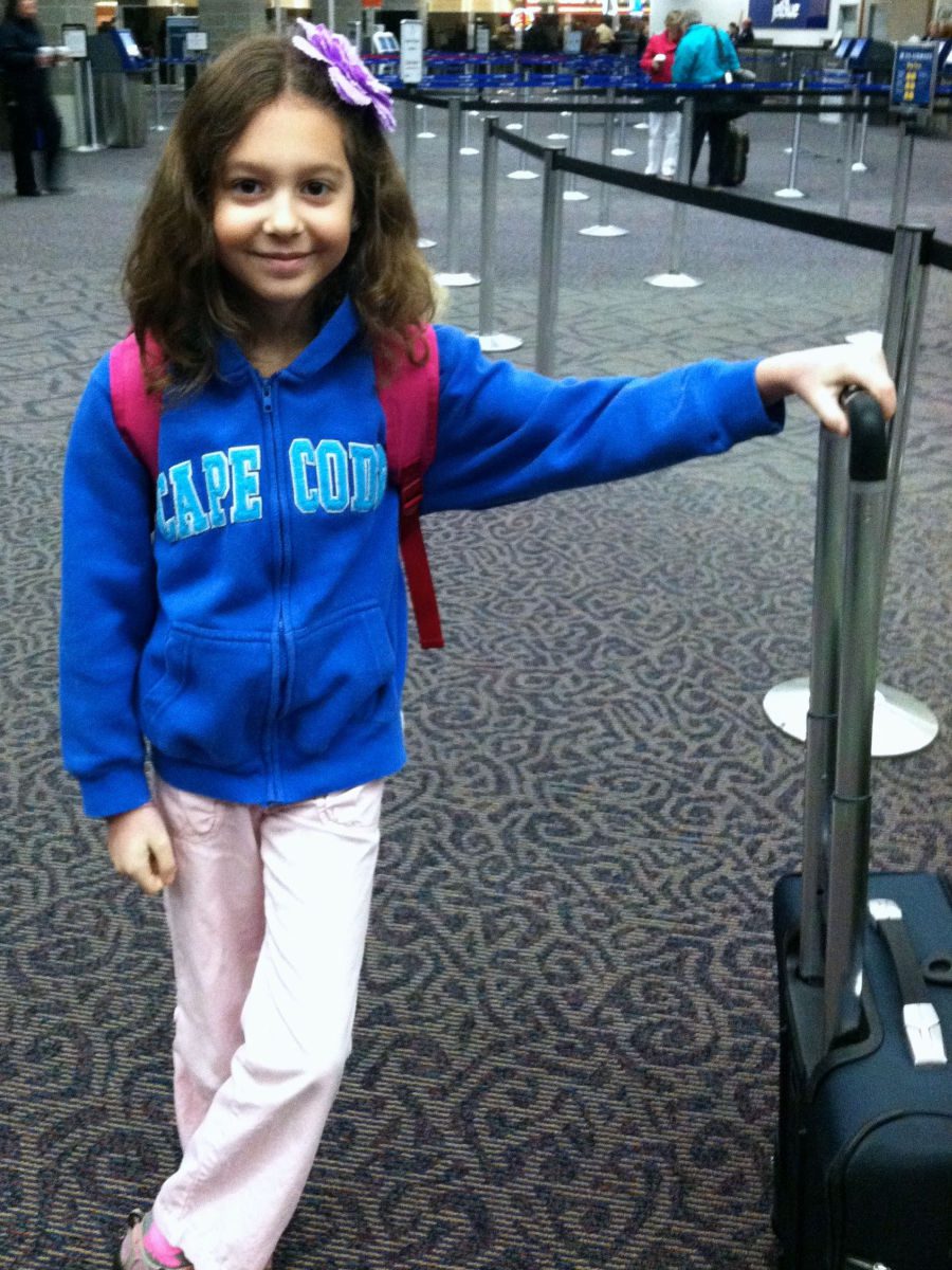 young girl at airport with suitcase