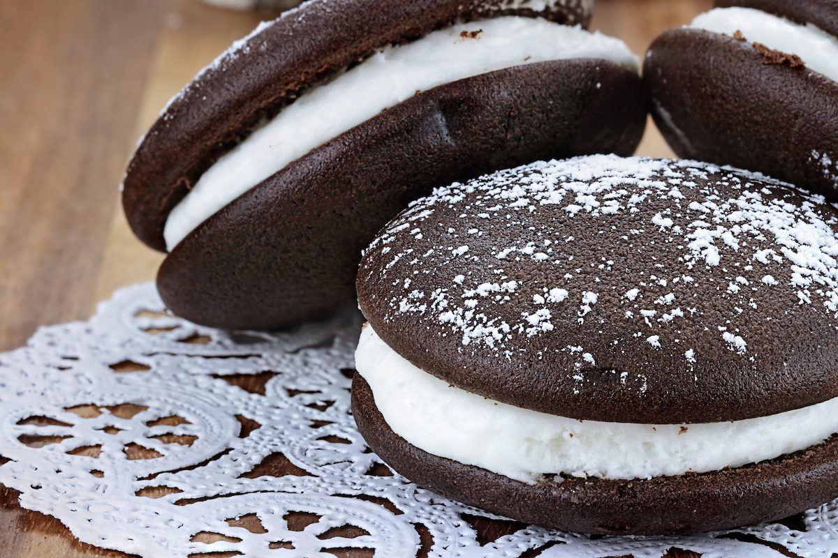 3 whoopie pies with powdered sugar on top on a doily