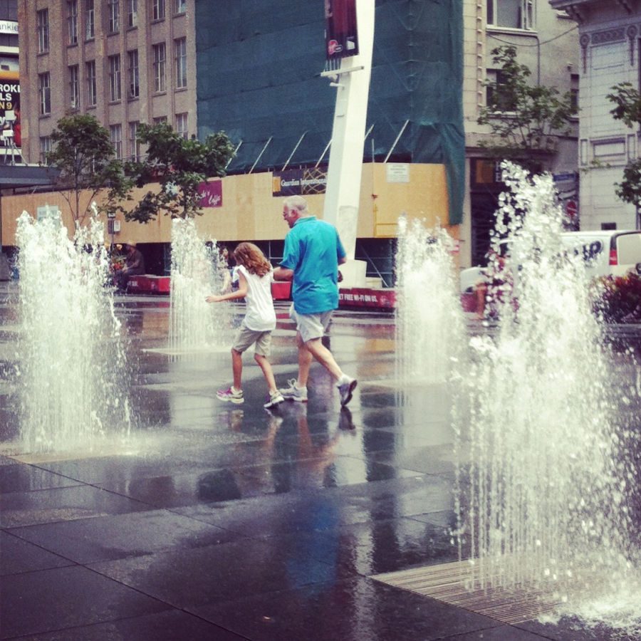 girl and dad running through fountains