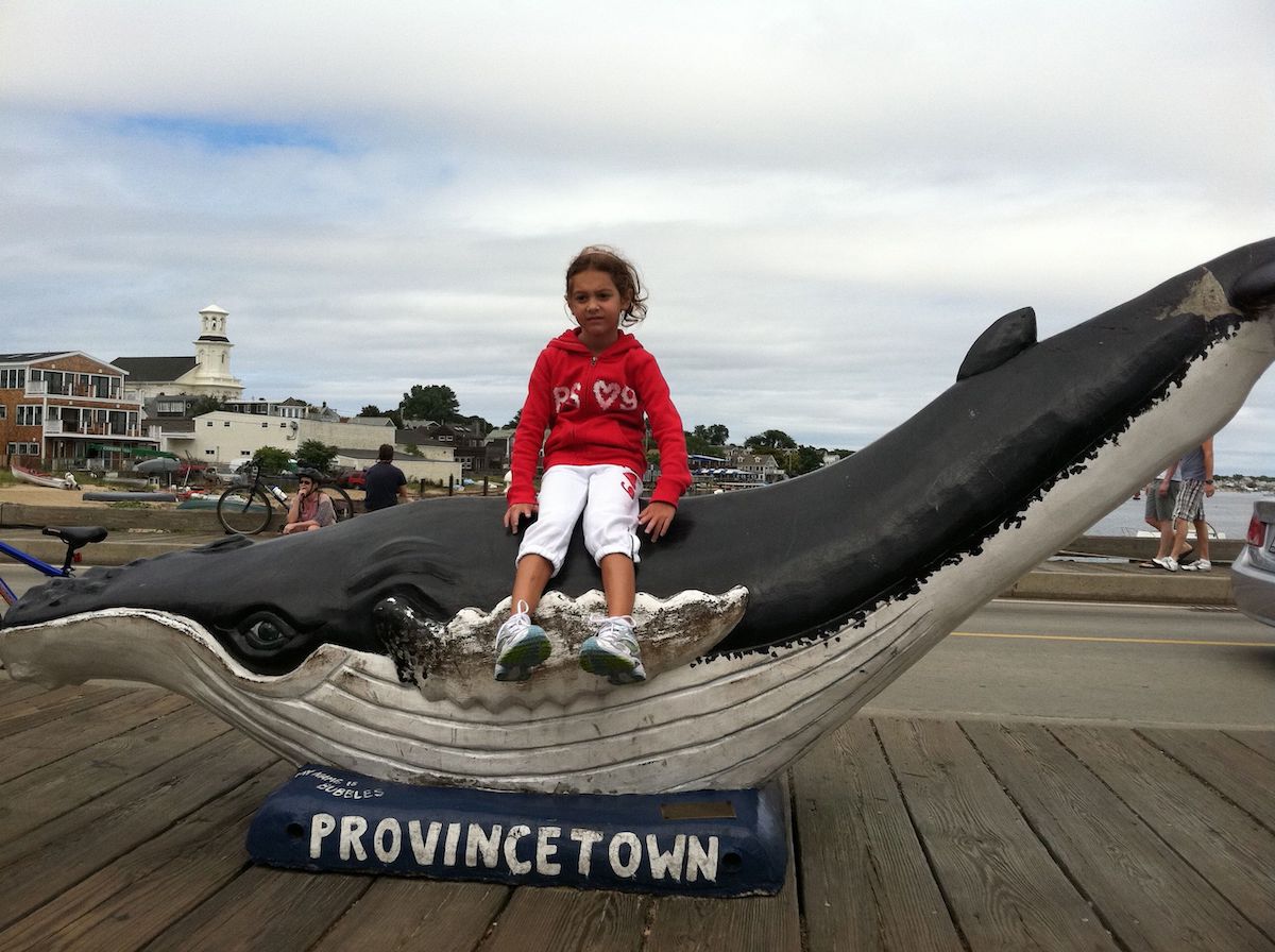 Girl on whale statue in Provincetown