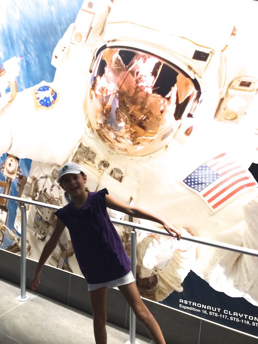 Girl in front of astronaut poster