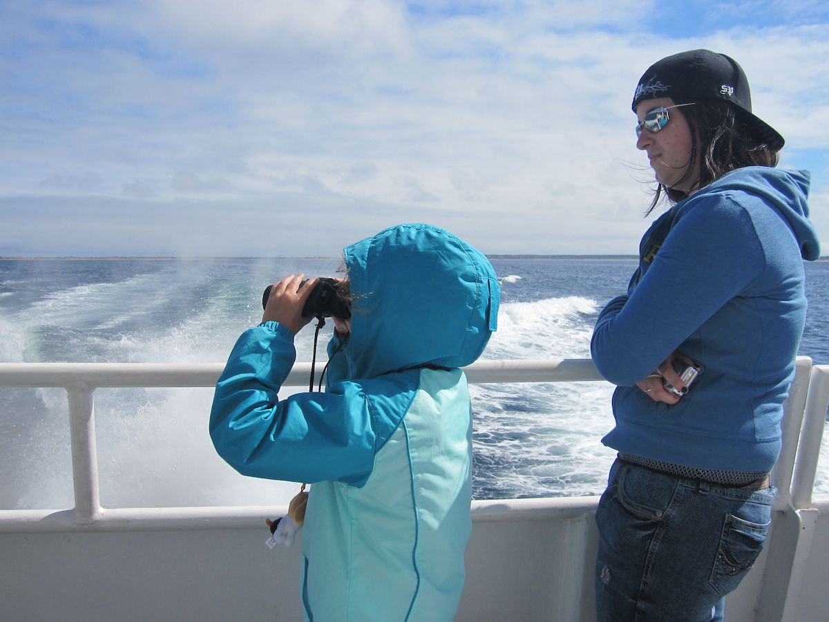 girl with binoculars on a whale watching boat