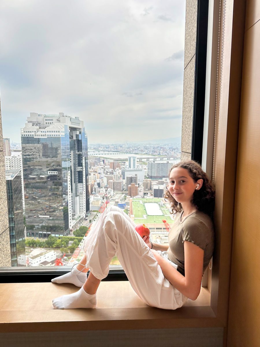 girl sitting in window looking at the view