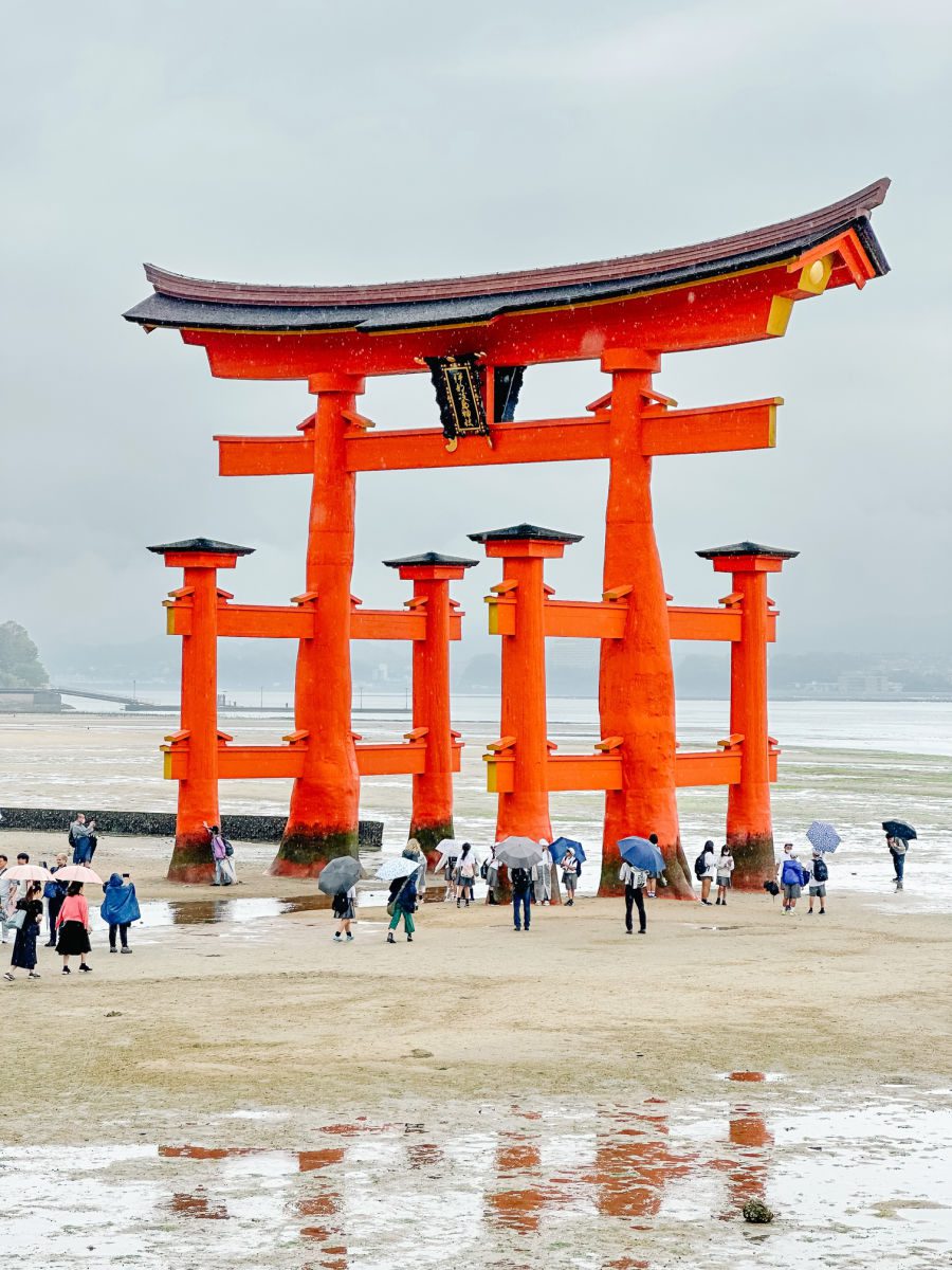 Torii gate with people under it in Miyajima