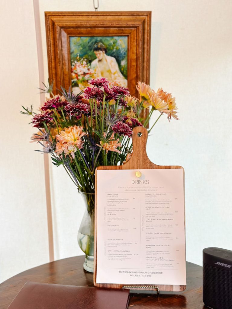 drinks menu on board in front of vase of flowers