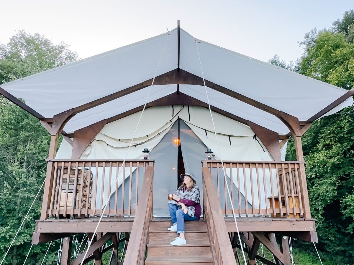 Tamara sitting on porch of Highwood Retreat glamping tent in Vermont