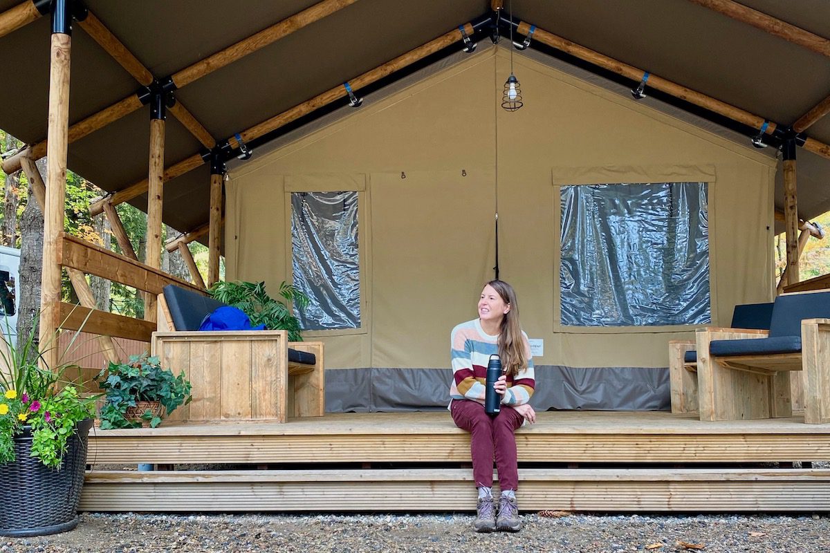 Tamara in front of the glamping tent at KOA Lincoln North Woodstock