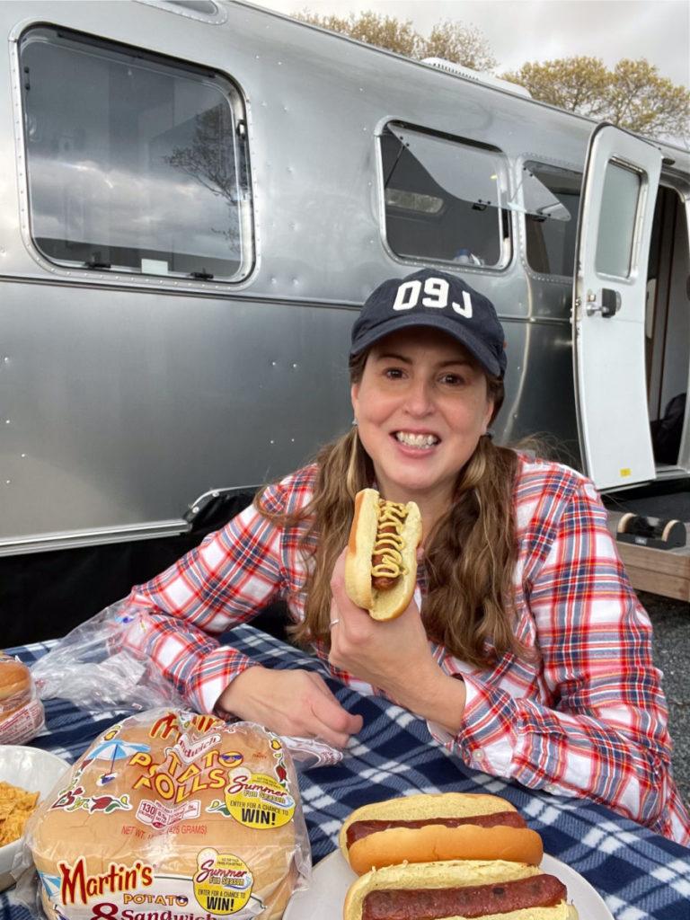Tamara eating hot dog outside of Airstream