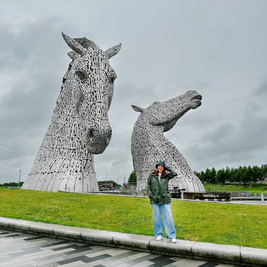 tamara in green coat and hat in front of the Kelpies