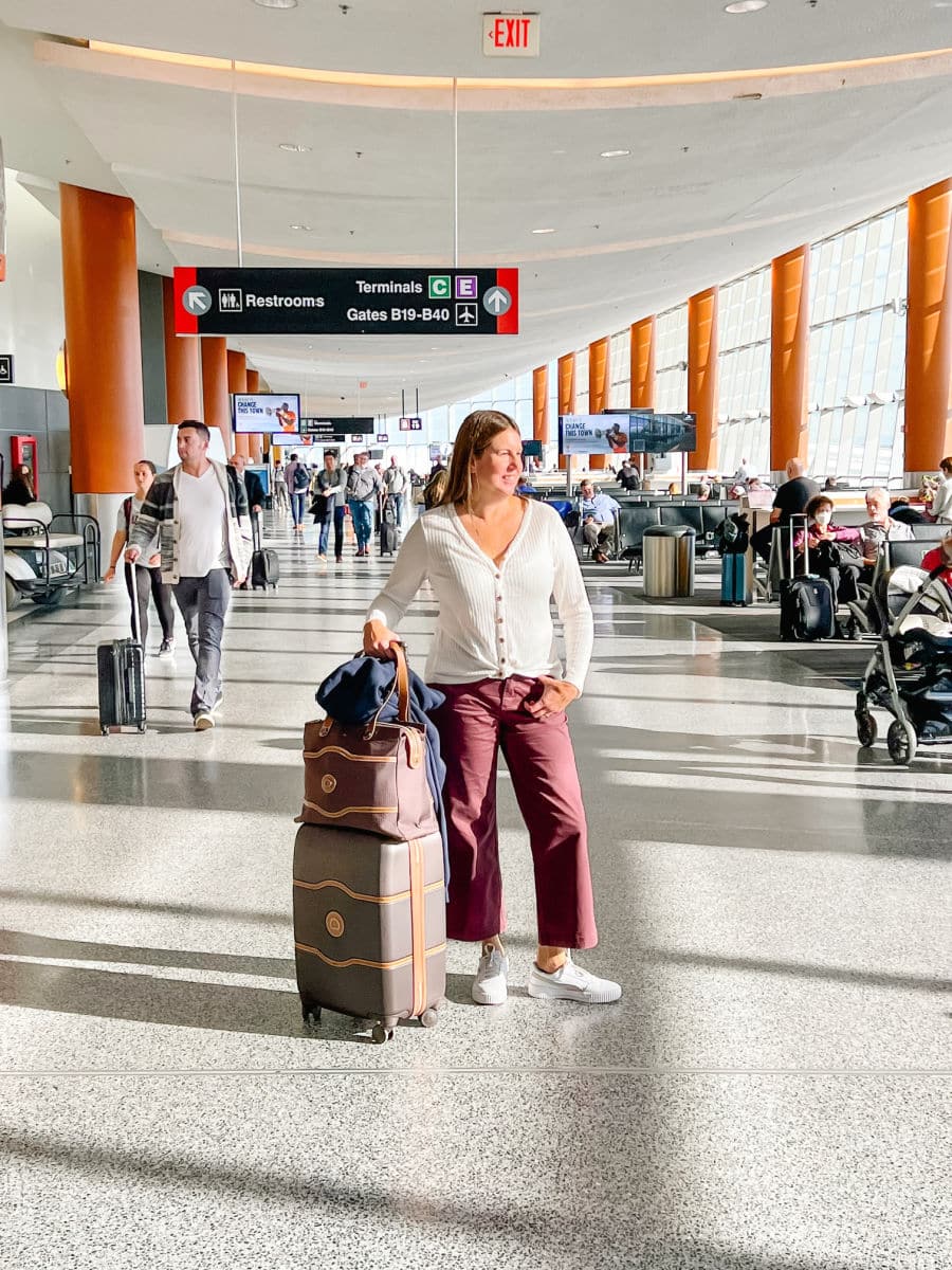Tamara in airport with Delsey suitcase luggage