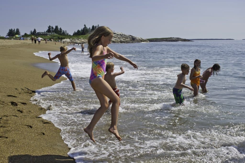 Kids jumping in water at Reid Beach Visit Maine